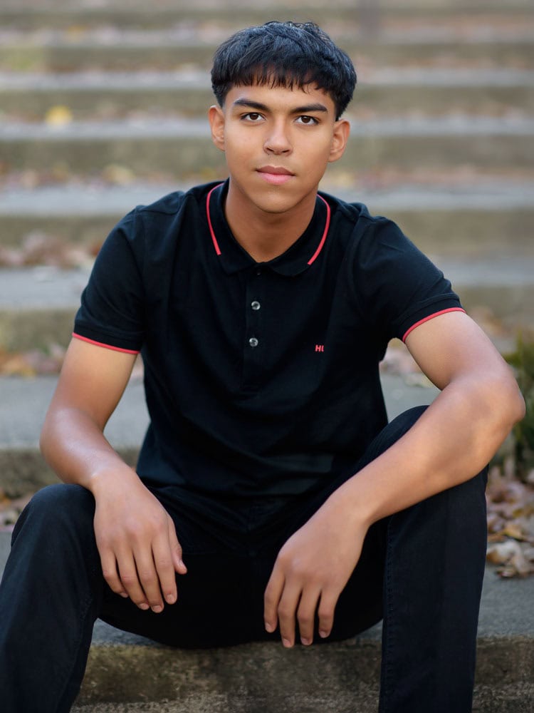 sitting boy in black shirt in a steps in a Park in Eagan