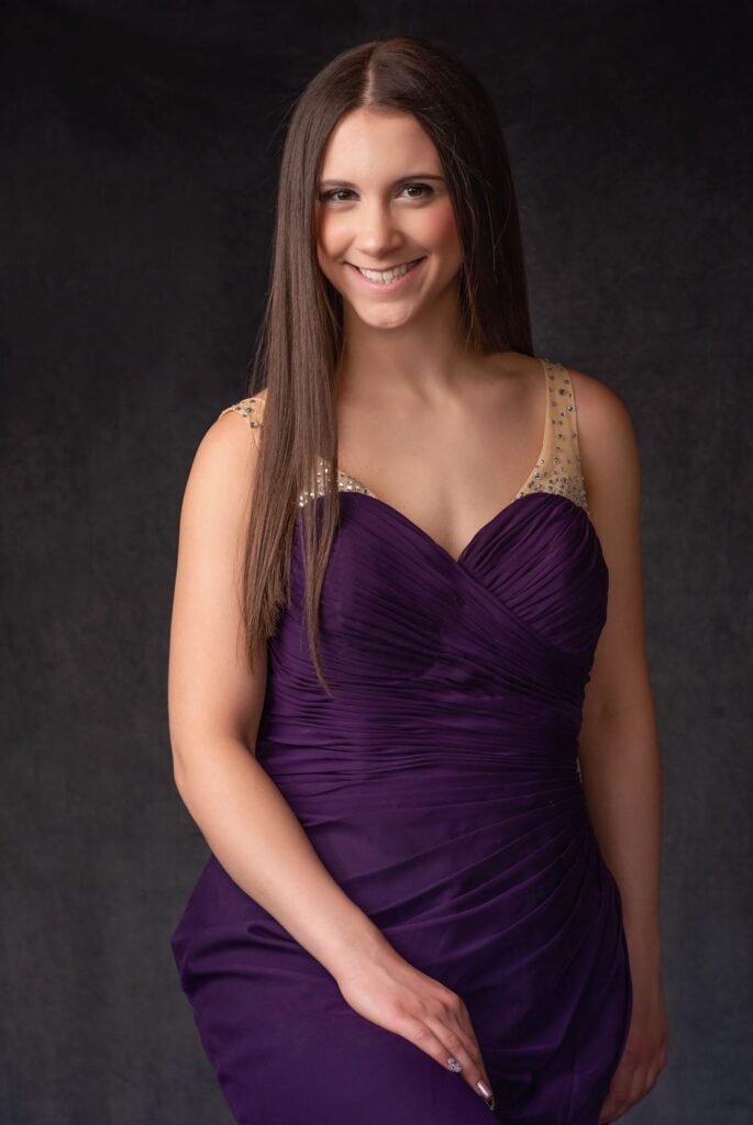 senior girl in a purple gown during her -in-home photo session.